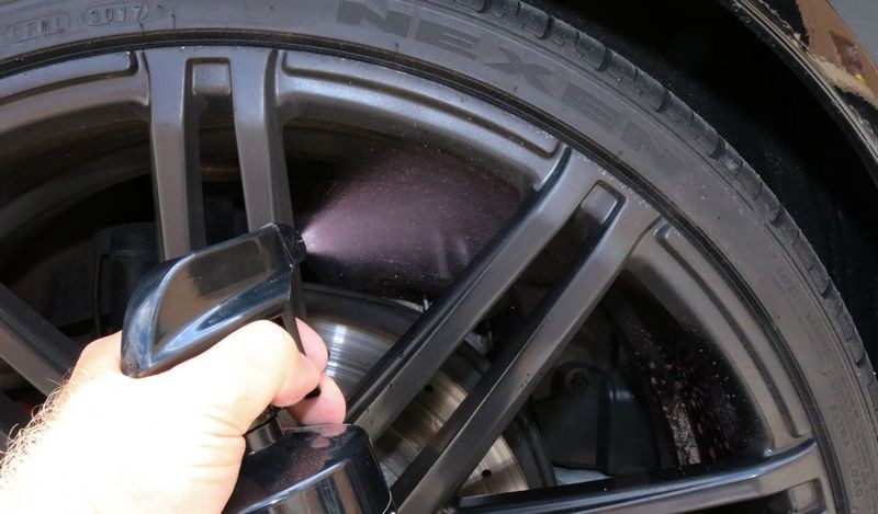 Spraying BLACKFIRE Tire & Wheel Cleaner onto wheel barrels.