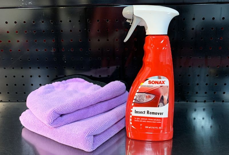 SONAX Insect Remover with two purple towels on table.